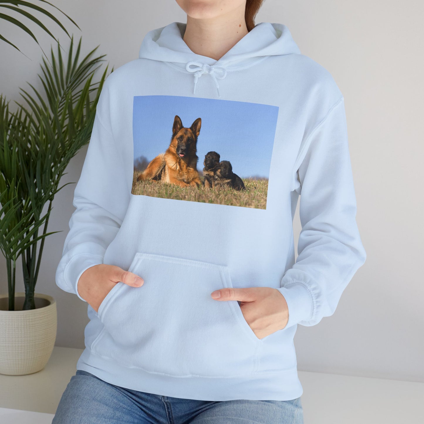 A Unisex Dog Lover Hoodie With a German Shepherd Lying on the Grass With Two Puppies